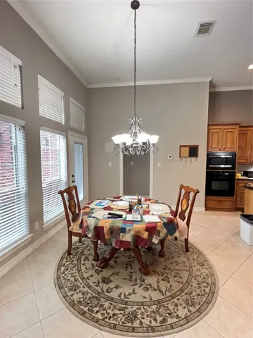 a dining room with furniture a chandelier and window