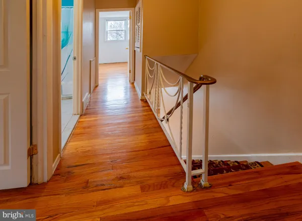 a view of a hallway with wooden floor and staircase