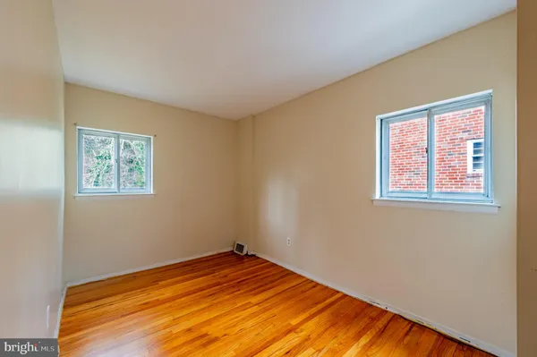 a view of empty room with wooden floor