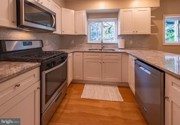 a kitchen with a sink stove and microwave