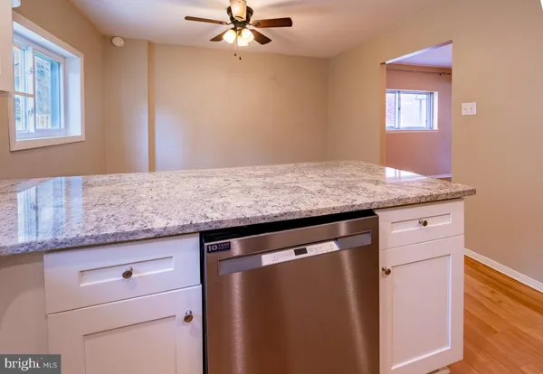 a utility room with granite countertop cabinets washer and dryer