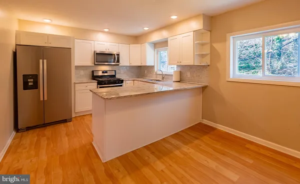 a kitchen with a sink a microwave a refrigerator and cabinets