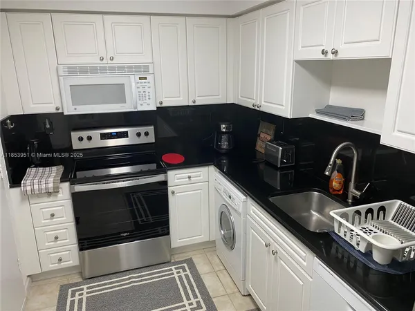 a kitchen with granite countertop a stove and a microwave