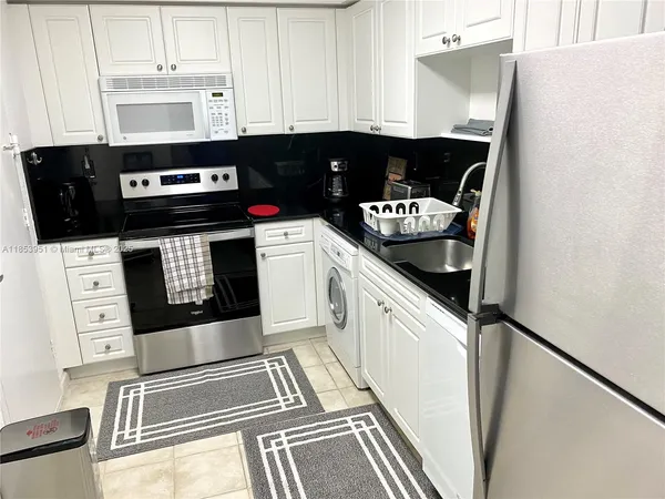 a kitchen with stainless steel appliances granite countertop a stove and a microwave