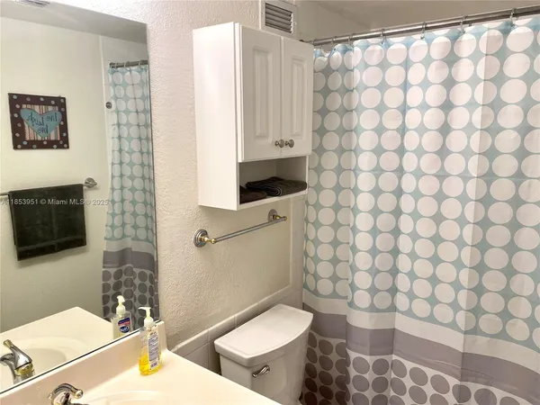 a bathroom with a toilet and a shower curtain