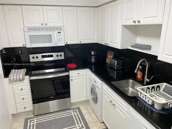 a kitchen with granite countertop a stove and a microwave