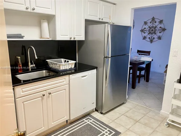a kitchen with stainless steel appliances granite countertop a refrigerator sink and cabinets