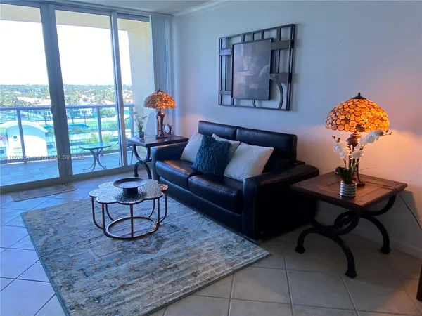 a living room with furniture and a floor to ceiling window