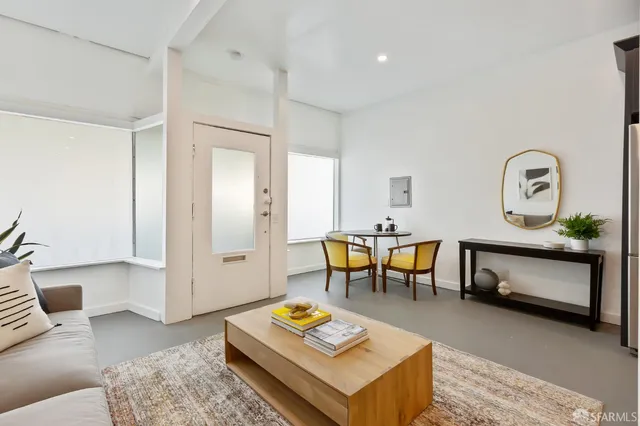 a living room with furniture a rug and a table