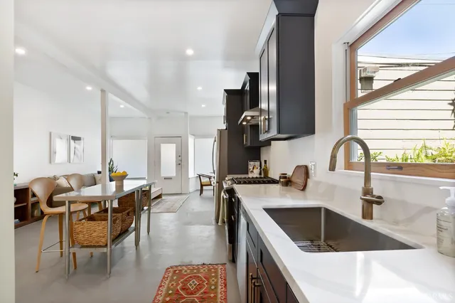 a kitchen with a sink a stove and chairs