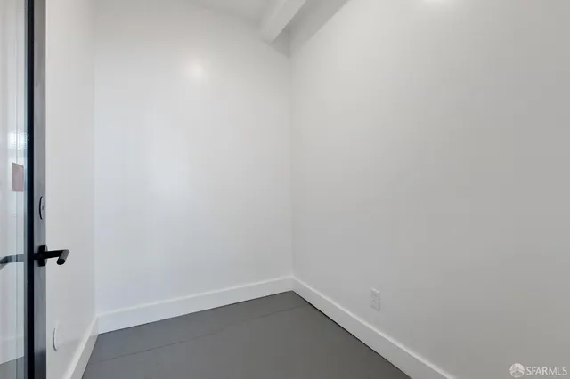 a view of an empty room with closet and a window