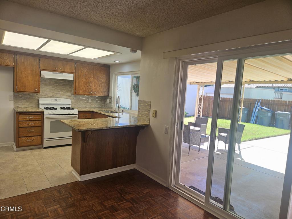 3510 Isle Way Oxnard, CA 93035 - Photo 10 of 26 a kitchen with stainless steel appliances granite countertop a stove a sink and a refrigerator