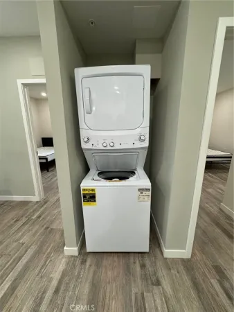 a utility room with wooden floor washer and dryer