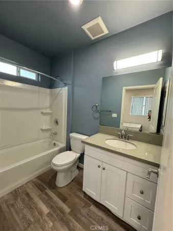 a bathroom with a double vanity sink toilet mirror and bathtub