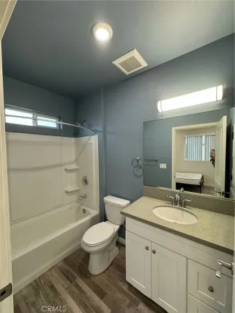 a bathroom with a granite countertop sink a toilet and shower