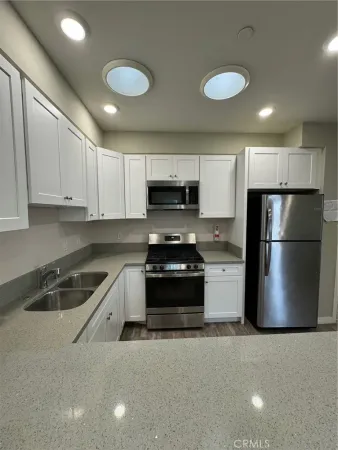 a kitchen with a refrigerator a stove a microwave and cabinets