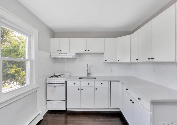 a kitchen with white cabinets and a stove
