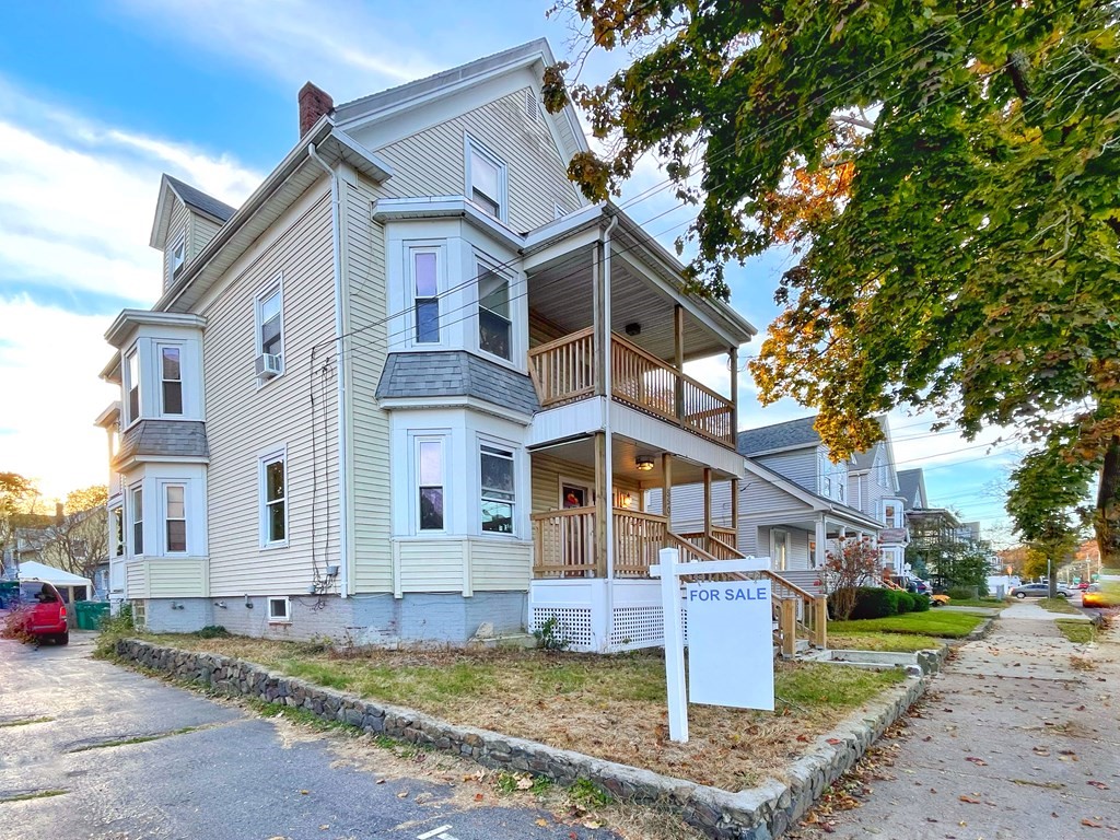 a view of a white house with large windows and a small yard