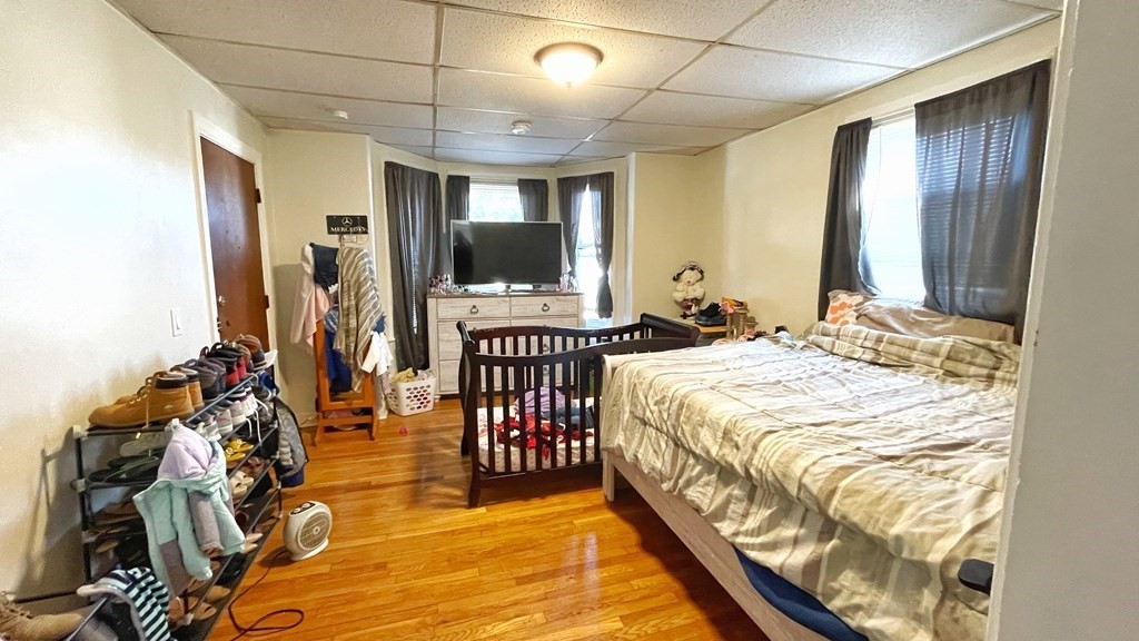 550 Eastern Avenue Lynn, MA 01902 - Photo 12 of 32 a spacious bedroom with a bed and a chandelier