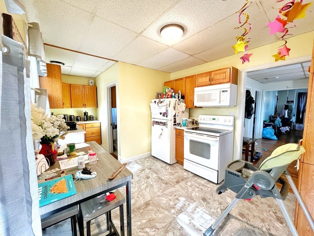 550 Eastern Avenue Lynn, MA 01902 - Photo 17 of 32 a kitchen with stainless steel appliances kitchen island granite countertop a refrigerator and a stove