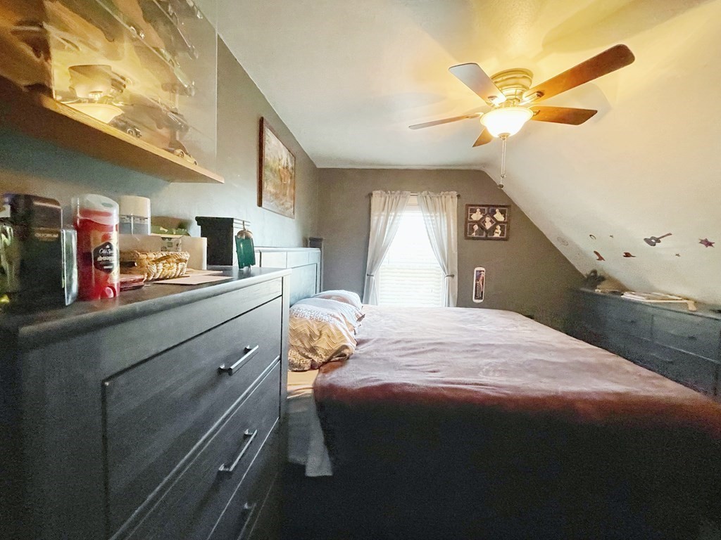 550 Eastern Avenue Lynn, MA 01902 - Photo 30 of 32 a bedroom with a bed and a chandelier