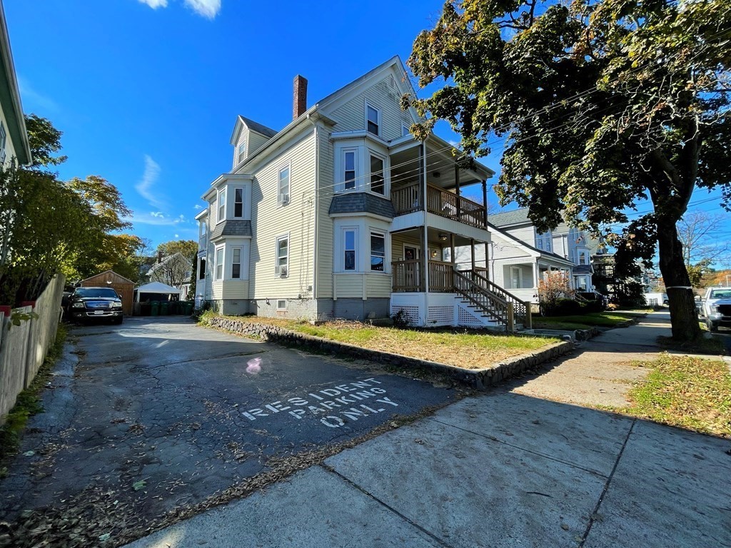 550 Eastern Avenue Lynn, MA 01902 - Photo 32 of 32 a view of a white house with swimming pool lawn chairs and a yard