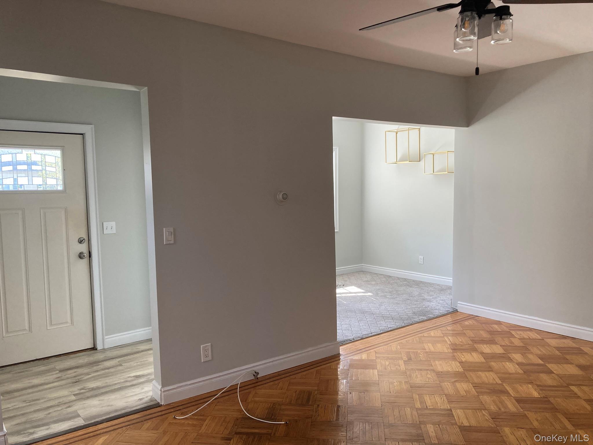 513 Marcellus Road, Unit 1 Williston Park, NY 11596 - Photo 8 of 11 an empty room with a ceiling fan and wooden floor