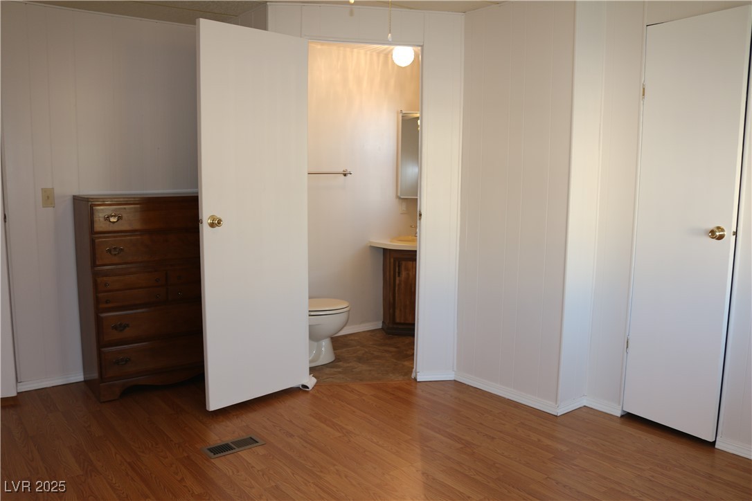 4633 Royal Ridge Boulevard Las Vegas, NV 89103 - Photo 9 of 13 Bathroom with visible vents, toilet, vanity, and wood finished floors