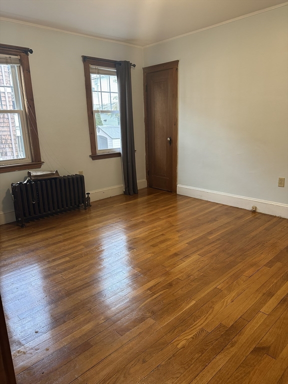 33 Amsden Street, Unit 1 Arlington, MA 02474 - Photo 9 of 18 an empty room with wooden floor and windows