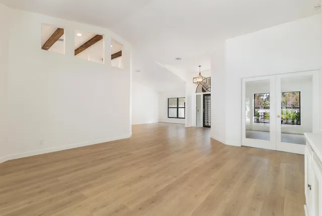 a view of a livingroom with wooden floor and a large window