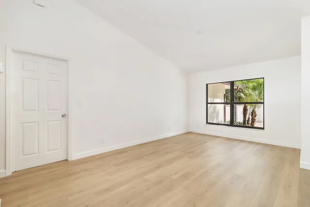 a kitchen with stainless steel appliances white cabinets and wooden floor