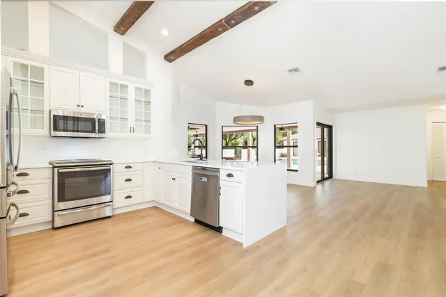 a kitchen with stainless steel appliances a refrigerator stove and microwave