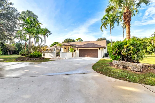 a front view of a house with a garden and a garage