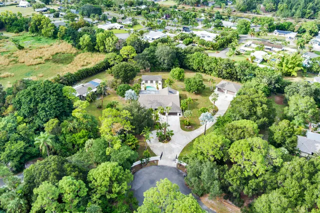 an aerial view of a house with a garden and large trees