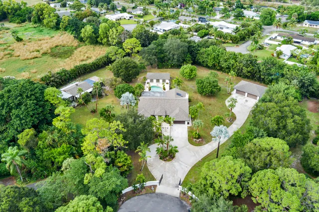 an aerial view of a house with a yard and lake view
