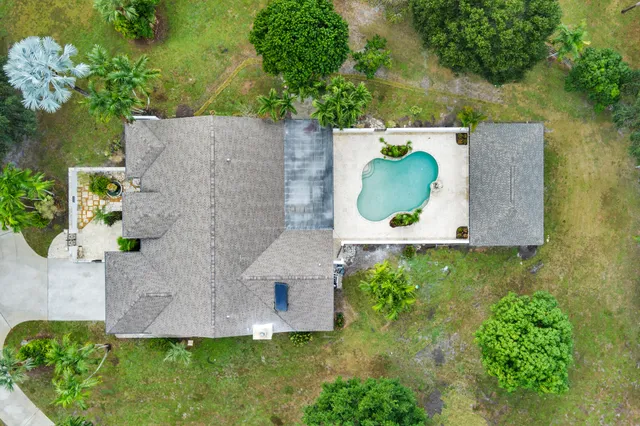 an aerial view of a house with a yard and lake view