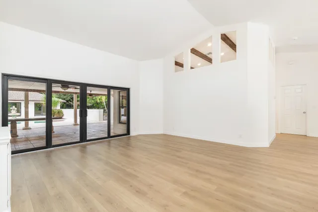 a view of a big room with wooden floor and windows
