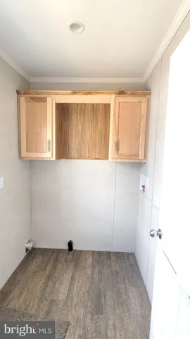 a view of a kitchen with wooden floor and a window