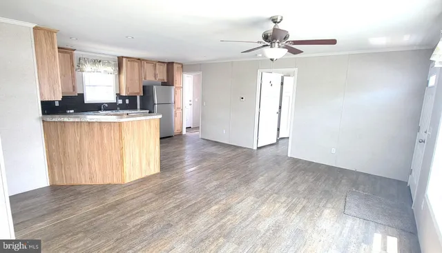 a view of kitchen with granite countertop cabinets and refrigerator