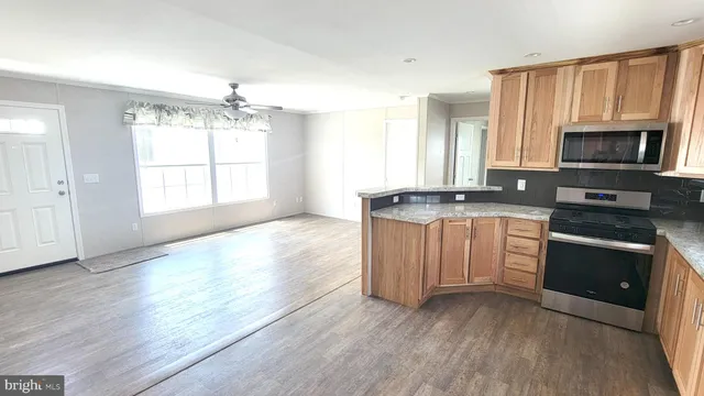 a kitchen with granite countertop a stove a sink and a microwave