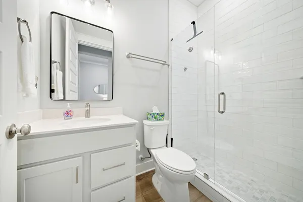 a bathroom with a sink a toilet and shower