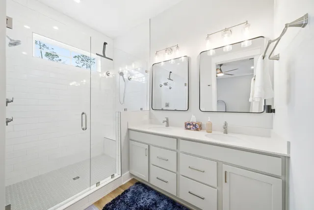 a bathroom with a double vanity sink mirror and shower