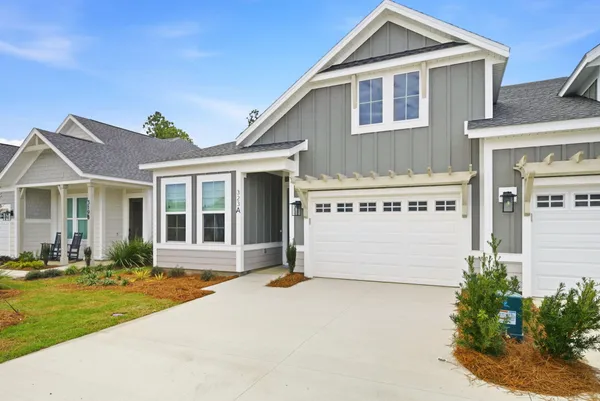 a front view of a house with a garden and yard