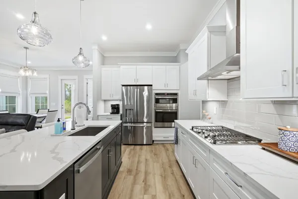 a kitchen with refrigerator a stove and a sink with cabinets