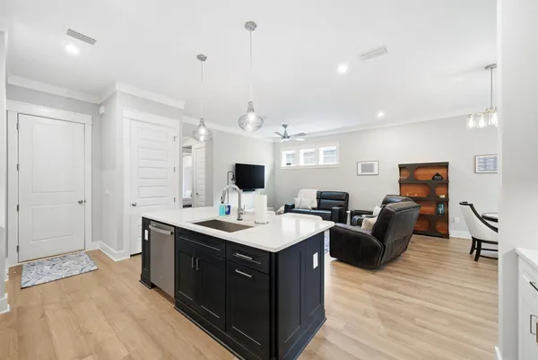 a view of living room kitchen island stainless steel appliances wooden floor and living room view