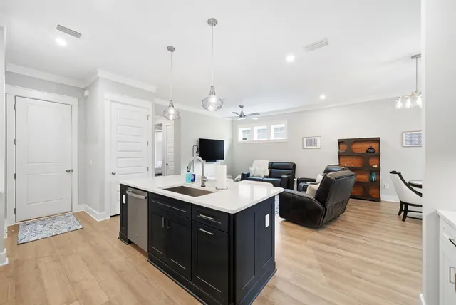 a view of living room kitchen island stainless steel appliances wooden floor and living room view
