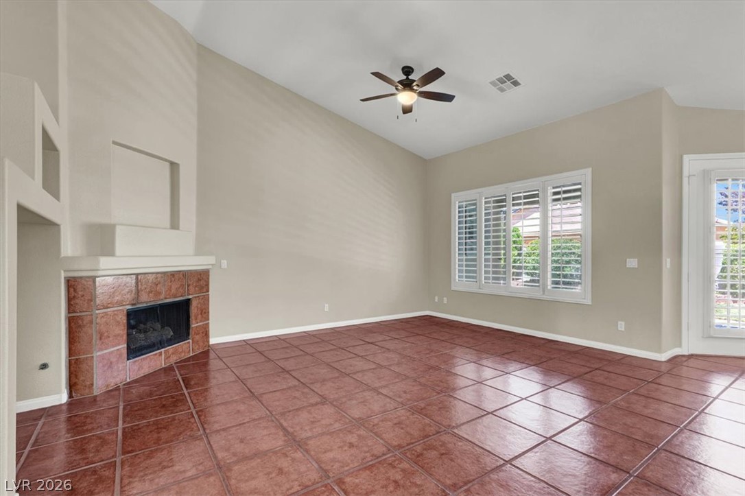 7308 Rustic Meadow Street Las Vegas, NV 89131 - Photo 7 of 27 A spacious living area offers vaulted ceilings and a warm, inviting tiled fireplace.