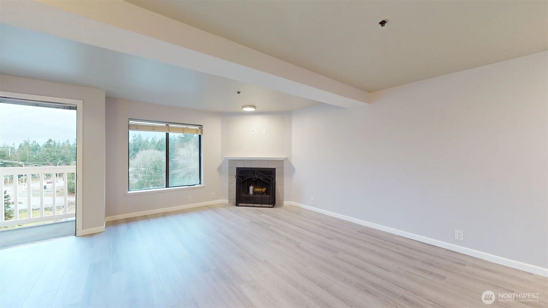29645 18th Avenue South, Unit A303 Federal Way, WA 98003 - Photo 4 of 19 an empty room with wooden floor fireplace and windows