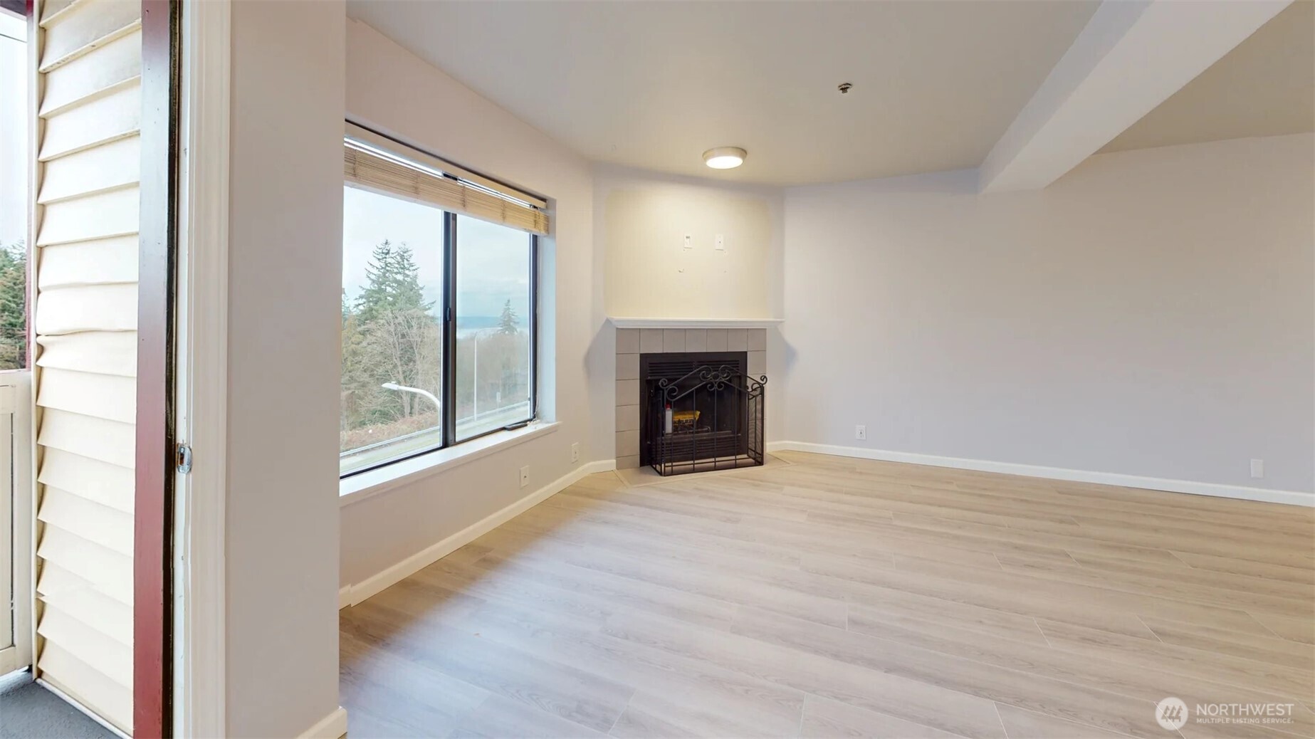 29645 18th Avenue South, Unit A303 Federal Way, WA 98003 - Photo 5 of 19 an empty room with wooden floor fireplace and windows