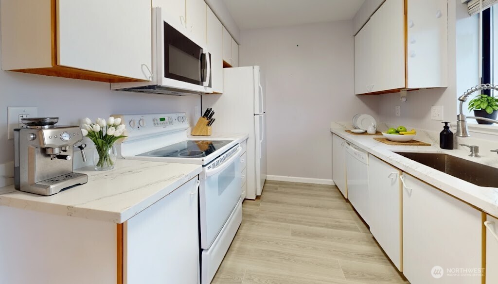 29645 18th Avenue South, Unit A303 Federal Way, WA 98003 - Photo 6 of 19 a kitchen with stainless steel appliances a sink a stove top oven a counter space and cabinets